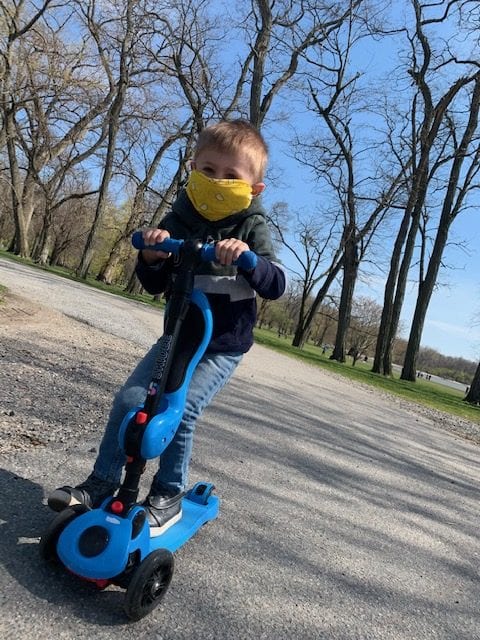 Hudson wears his mask so he can ride his scooter